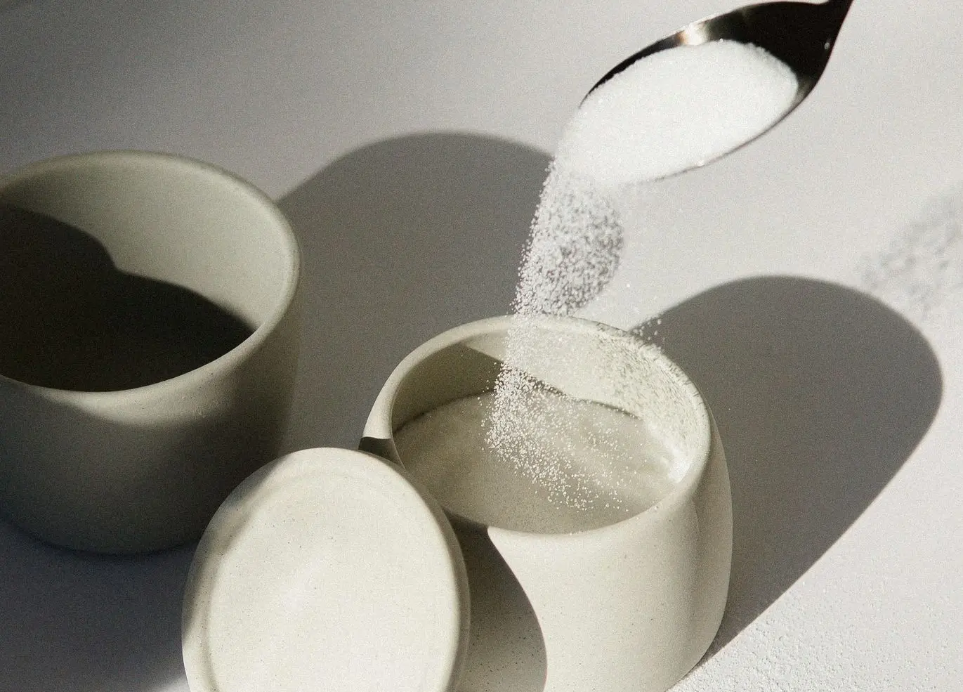 white ceramic mugs on white table